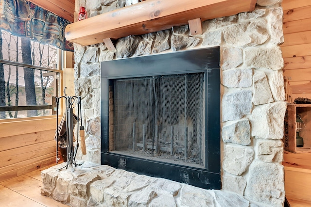 details with a stone fireplace and wooden walls