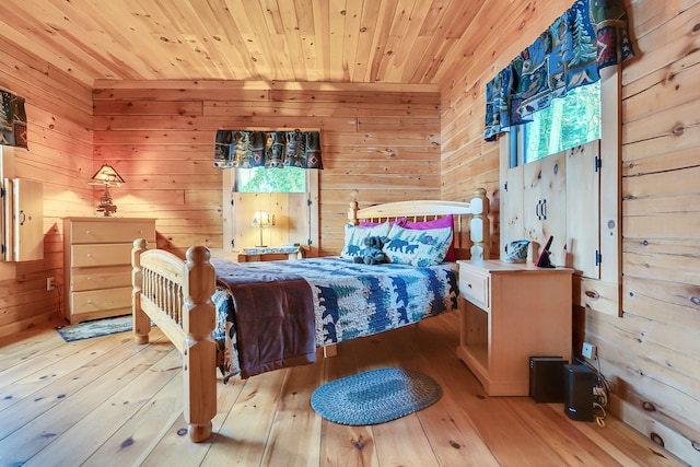 bedroom featuring light wood-type flooring, wooden ceiling, and wooden walls