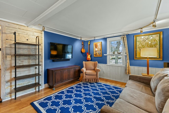 living room featuring crown molding, hardwood / wood-style floors, and wood walls