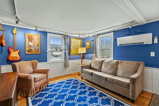 living room with plenty of natural light, wood-type flooring, an AC wall unit, and ornamental molding