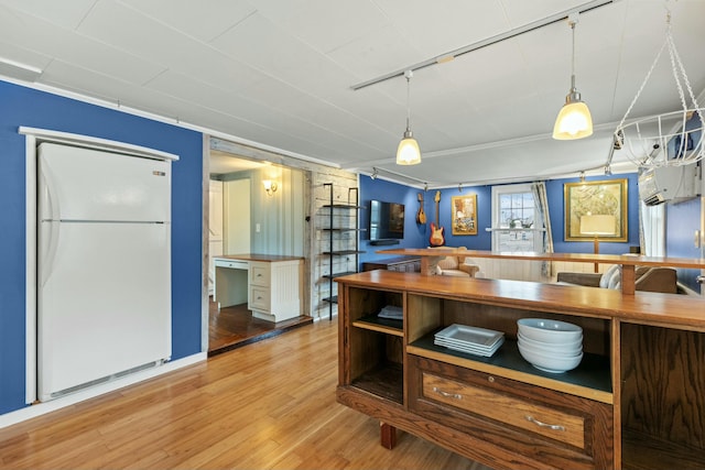 kitchen featuring pendant lighting, white fridge, and wood-type flooring