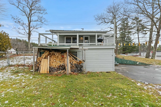 rear view of house with a yard and a balcony