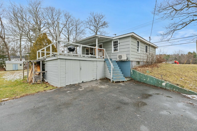 exterior space with a wall mounted AC and a shed