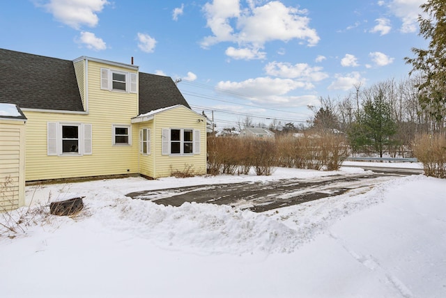 view of snow covered back of property