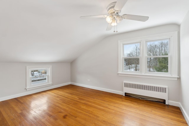 bonus room with ceiling fan, lofted ceiling, radiator heating unit, and light hardwood / wood-style floors