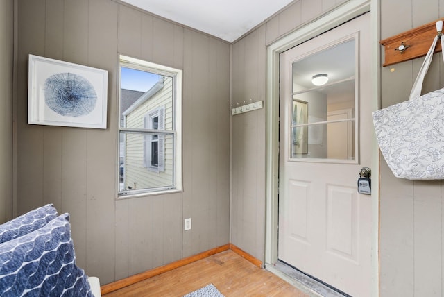 doorway with hardwood / wood-style floors and wood walls