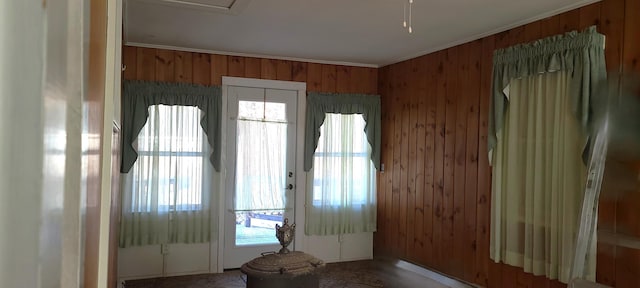 entryway featuring wooden walls and crown molding