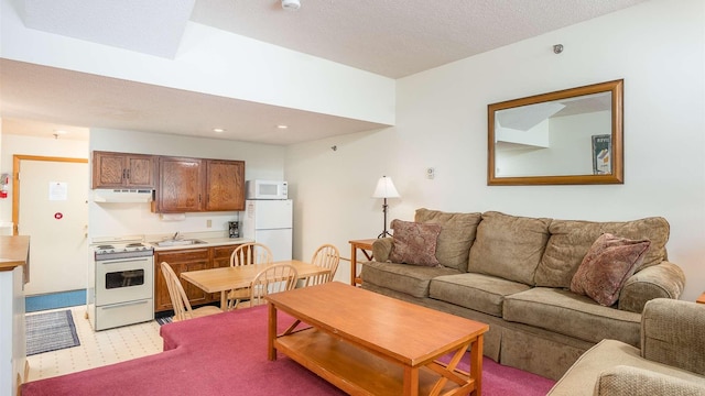 living room with light carpet, sink, and a textured ceiling