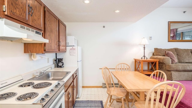 kitchen with sink, a baseboard radiator, and white appliances