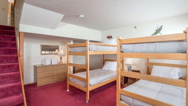 bedroom featuring dark carpet and a textured ceiling