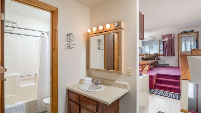 full bathroom with shower / bath combination with curtain, vanity, a textured ceiling, and toilet