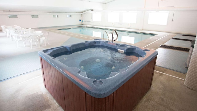 view of swimming pool with a hot tub