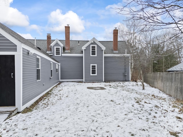 view of snow covered back of property