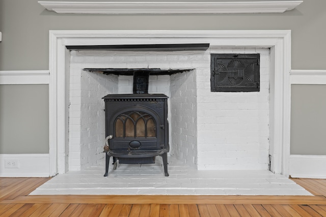 interior details featuring hardwood / wood-style floors and a wood stove