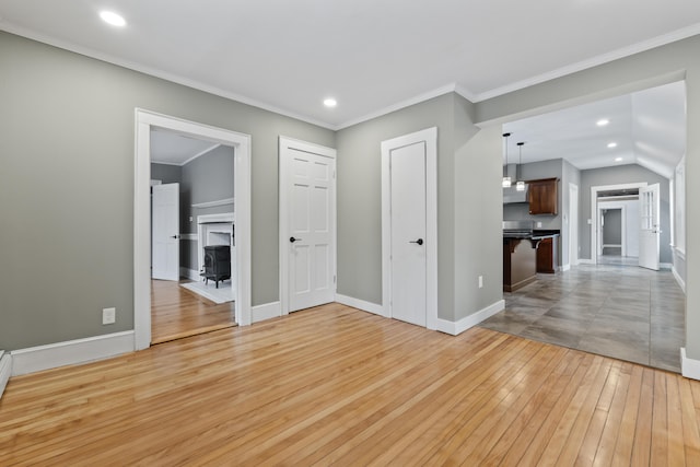 spare room with light wood-type flooring and crown molding