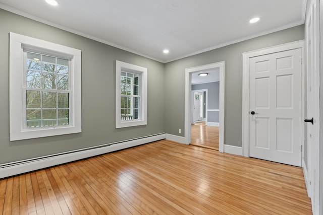 unfurnished room with light hardwood / wood-style flooring, ornamental molding, and a baseboard heating unit