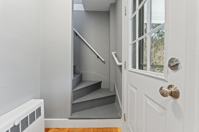 stairway featuring hardwood / wood-style floors and radiator