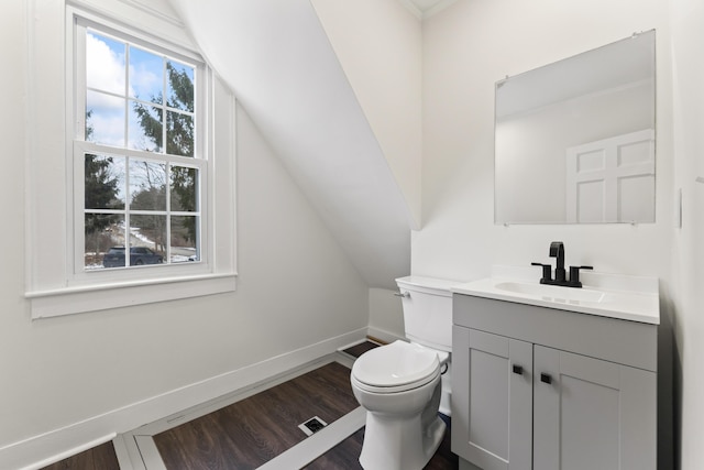 bathroom featuring vanity, toilet, wood-type flooring, and lofted ceiling