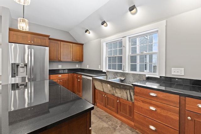 kitchen with decorative light fixtures, stainless steel appliances, dark stone counters, and vaulted ceiling