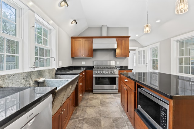 kitchen with stainless steel appliances, hanging light fixtures, lofted ceiling, and wall chimney exhaust hood