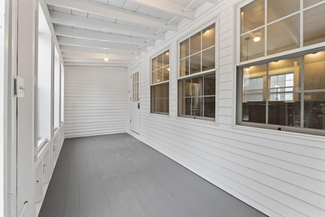 unfurnished sunroom featuring beam ceiling