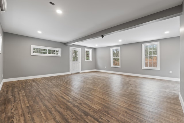 spare room with beam ceiling and dark hardwood / wood-style floors