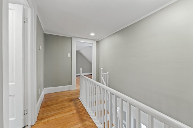 corridor with light hardwood / wood-style flooring, baseboard heating, and crown molding