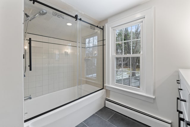 bathroom featuring baseboard heating, tile patterned floors, vanity, and bath / shower combo with glass door