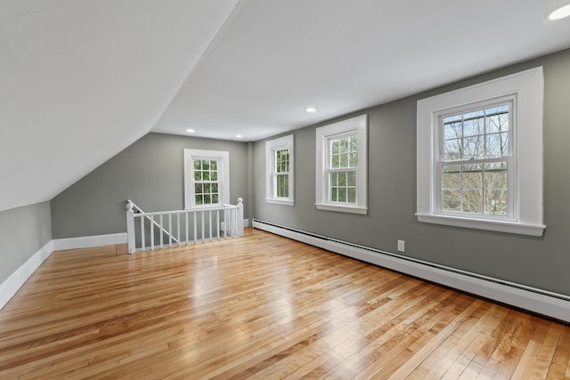 bonus room with plenty of natural light, light hardwood / wood-style floors, and a baseboard radiator