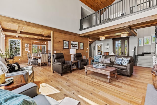 18 Sheehans Island Rd, Raymond, ME 04071 - living room featuring wooden walls, wood-type flooring, stairway, beam ceiling, and wood ceiling