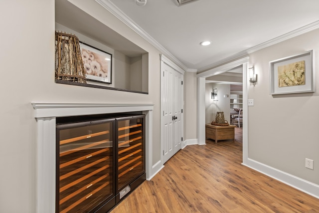 18 Sheehans Island Rd, Raymond, ME 04071 - hallway featuring beverage cooler, ornamental molding, wood finished floors, baseboards, and recessed lighting