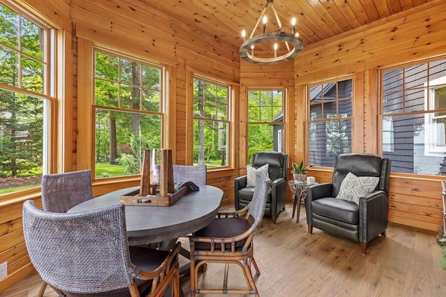 18 Sheehans Island Rd, Raymond, ME 04071 - dining space with a chandelier, wood walls, light wood-style floors, healthy amount of natural light, and wood ceiling