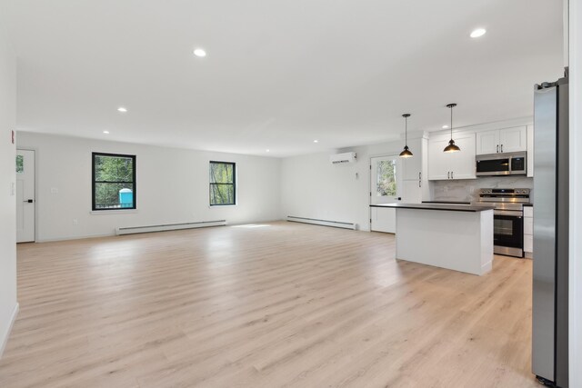 17 Ward Rd, Sebago, ME 04029 - unfurnished living room featuring baseboard heating, a baseboard radiator, an AC wall unit, and recessed lighting