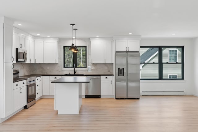 17 Ward Rd, Sebago, ME 04029 - kitchen featuring a sink, dark countertops, baseboard heating, stainless steel appliances, and light wood-style flooring