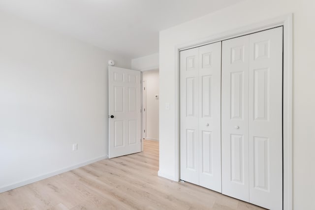 17 Ward Rd, Sebago, ME 04029 - unfurnished bedroom with light wood-style floors, a closet, and baseboards