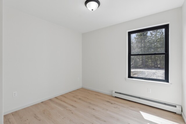 17 Ward Rd, Sebago, ME 04029 - empty room featuring a baseboard heating unit, baseboards, and wood finished floors