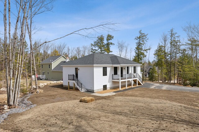 17 Ward Rd, Sebago, ME 04029 - rear view of house with a porch, aphalt driveway, and roof with shingles