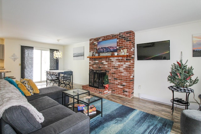 living room featuring a fireplace, hardwood / wood-style floors, a chandelier, and crown molding