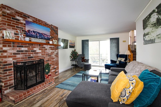 living room featuring crown molding, hardwood / wood-style floors, and a brick fireplace