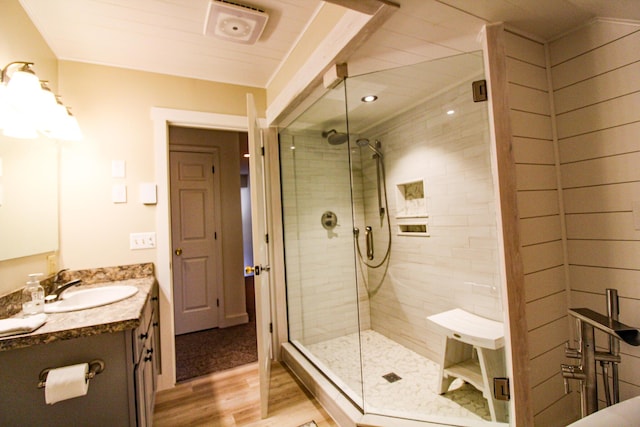 bathroom with hardwood / wood-style floors, vanity, and an enclosed shower