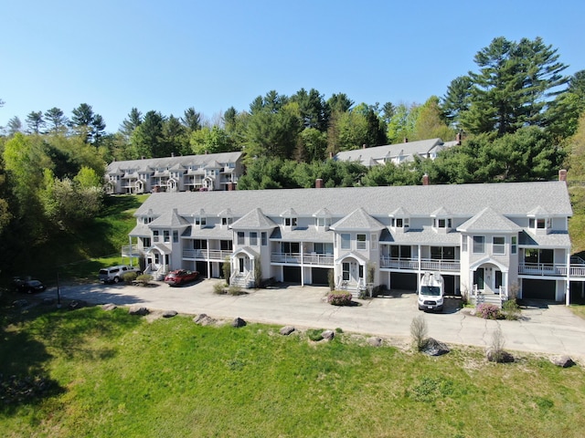 135 Vernon St Unit 4E, Bethel, ME 04217 - rear view of property with a balcony, view of wooded area, and a yard