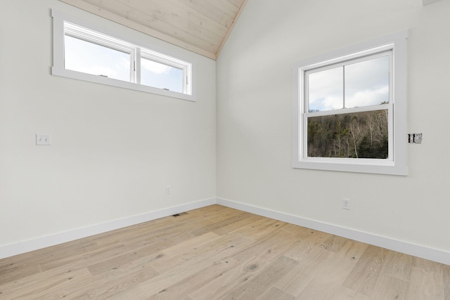 empty room featuring vaulted ceiling and light wood-type flooring