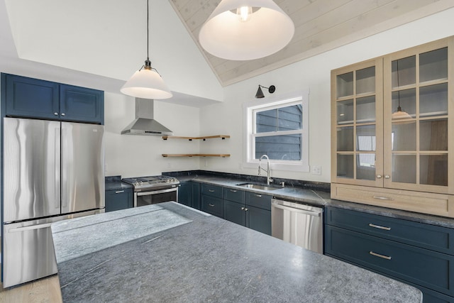 kitchen with wall chimney exhaust hood, blue cabinets, sink, hanging light fixtures, and appliances with stainless steel finishes