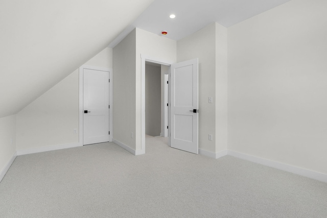 additional living space featuring light carpet and lofted ceiling