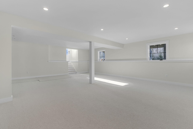 basement with a wealth of natural light and light colored carpet