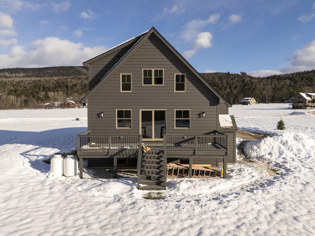 snow covered property with a deck