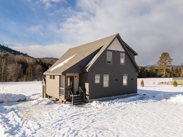 view of snow covered back of property