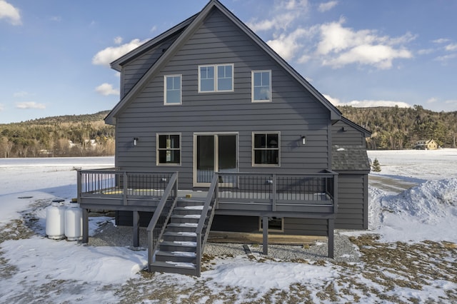 snow covered house featuring a deck