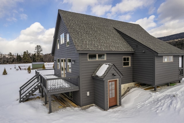 snow covered property with a wooden deck