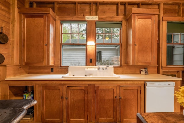 137 Birch Ln, Belgrade, ME 04917 - kitchen with dishwasher, a sink, wooden walls, brown cabinetry, and light countertops